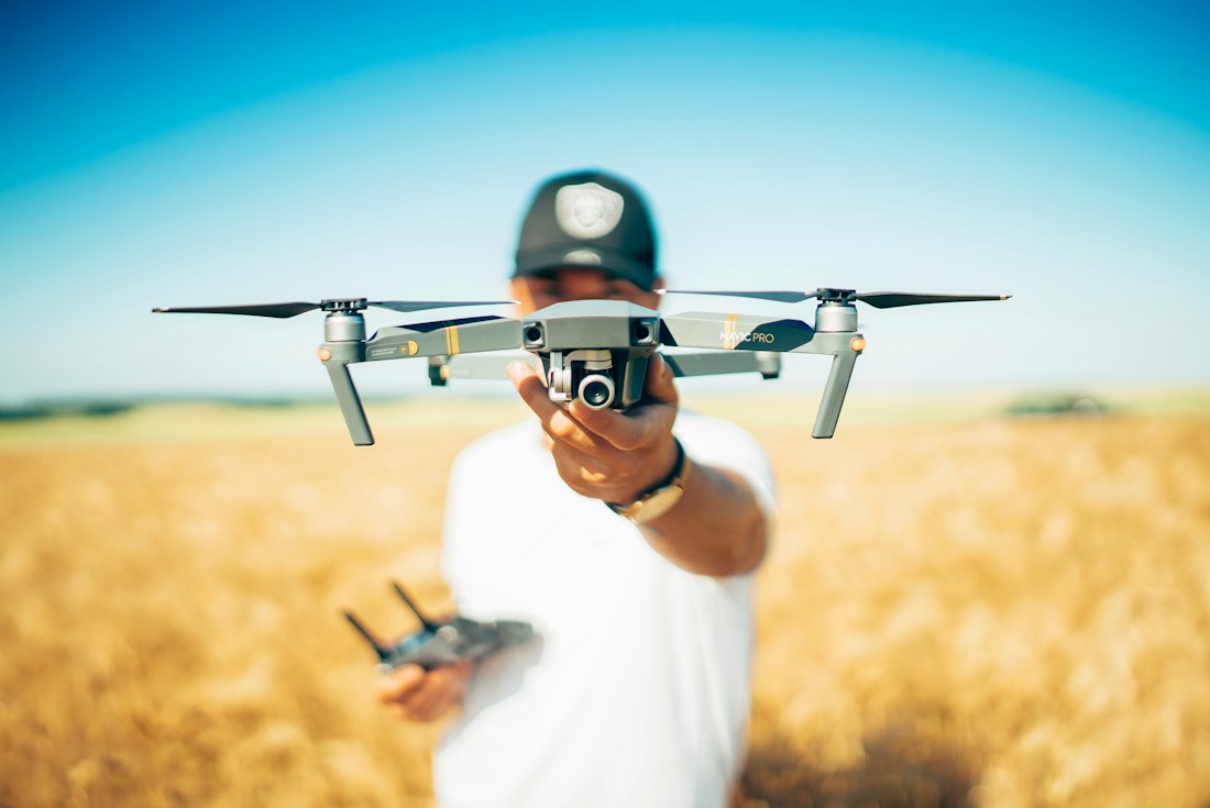 A drone operator holding a camera drone